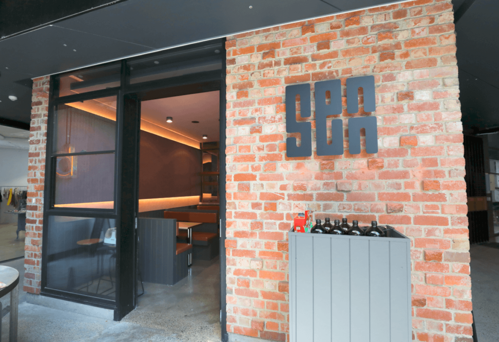 Custom graffitti wall art, earth and terracotta colour palette and welcoming dining area for this hospitality fit out for Senn Noods